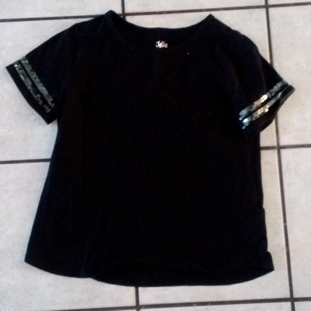 A black shirt sparkles around the sleeve
